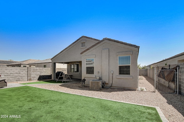 back of property featuring a yard, stucco siding, cooling unit, and a fenced backyard