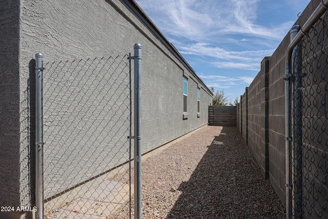 view of side of home with a fenced backyard and stucco siding