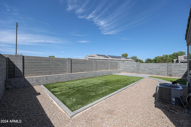 view of yard with central AC and a fenced backyard