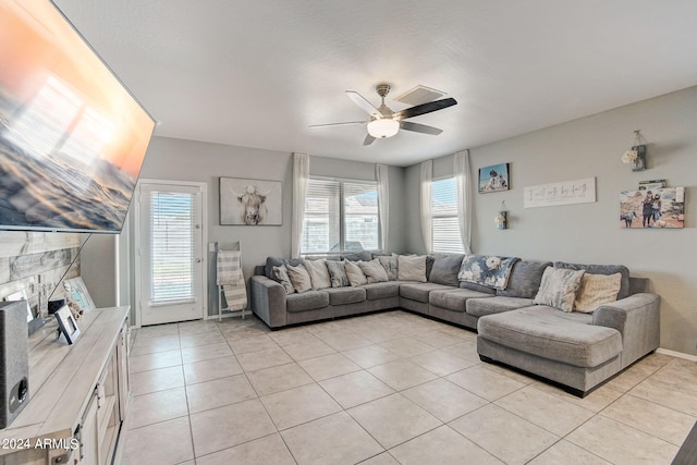 living area featuring light tile patterned floors, a fireplace, a wealth of natural light, and ceiling fan