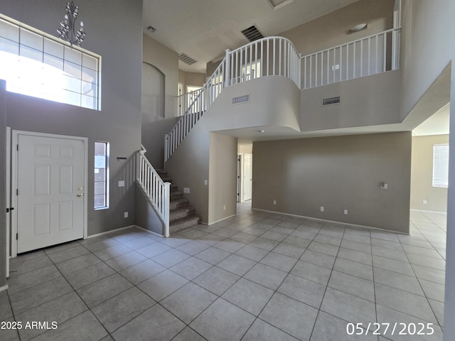 43455 W Chisholm Dr, Maricopa, AZ 85138 - foyer with tile patterned flooring, a high ceiling, stairway, and baseboards