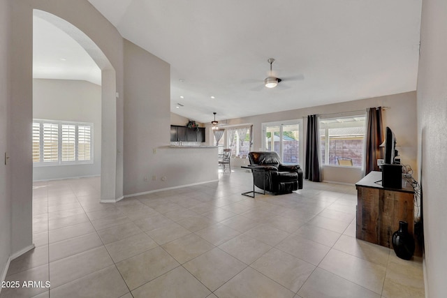 tiled living room with ceiling fan and vaulted ceiling