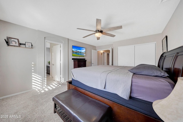 bedroom with ceiling fan, a closet, and light carpet