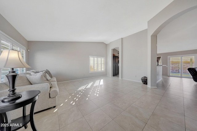 living room featuring lofted ceiling and light tile patterned floors