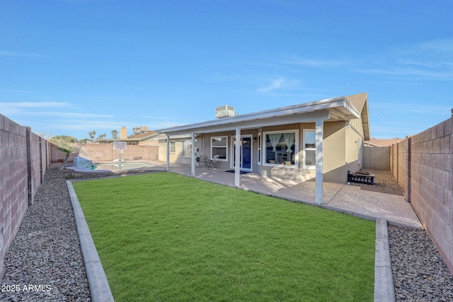 back of property with a pool, a yard, and a patio area