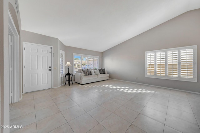 unfurnished living room featuring vaulted ceiling and light tile patterned floors