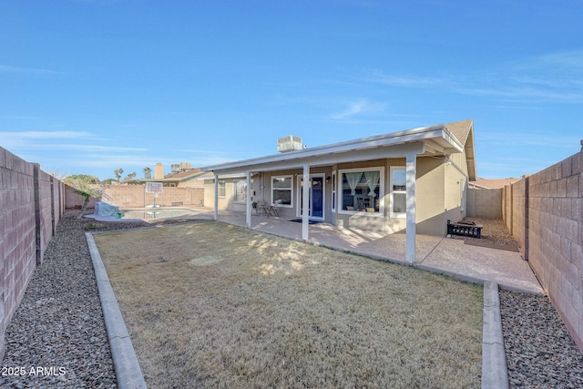 rear view of property with a swimming pool and a patio area