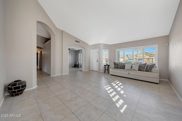 unfurnished living room with light tile patterned flooring and high vaulted ceiling