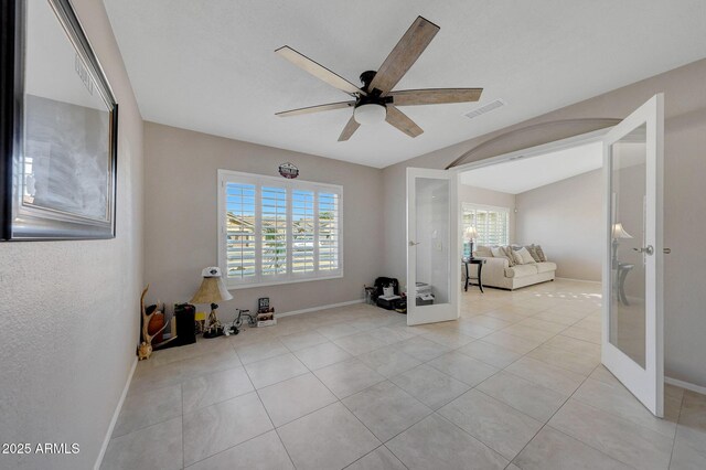 interior space with light tile patterned floors, french doors, a healthy amount of sunlight, and ceiling fan