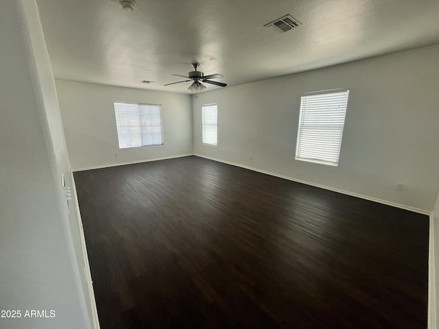 30944 N Bramwell Ave, San Tan Valley, AZ 85143 - empty room featuring visible vents, a ceiling fan, baseboards, and dark wood finished floors
