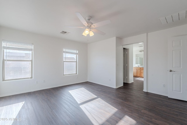 30944 N Bramwell Ave, San Tan Valley, AZ 85143 - spare room with visible vents, baseboards, ceiling fan, and dark wood-style floors