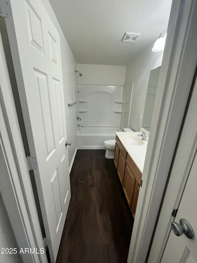 30944 N Bramwell Ave, San Tan Valley, AZ 85143 - bathroom with shower / bathing tub combination, visible vents, wood finished floors, vanity, and toilet