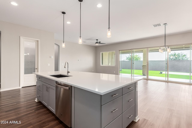 kitchen featuring gray cabinets, an island with sink, decorative light fixtures, and stainless steel dishwasher