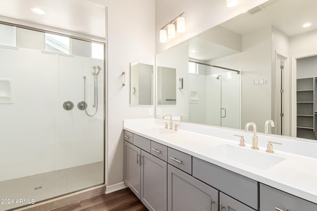 bathroom featuring wood-type flooring, walk in shower, and vanity