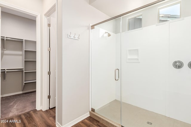 bathroom featuring a shower with shower door and hardwood / wood-style flooring