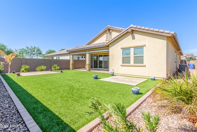 back of property featuring a patio and a lawn