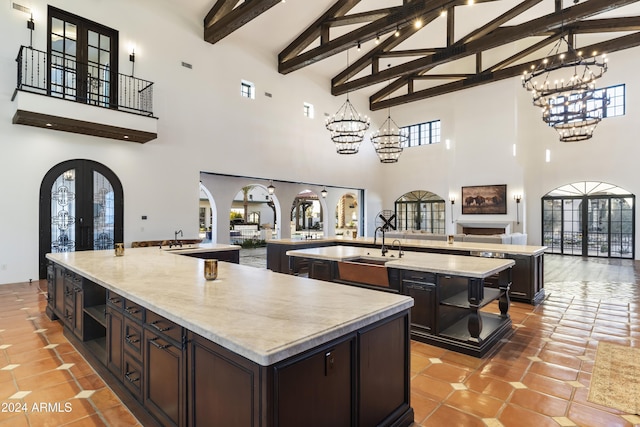 kitchen with a large island, tile patterned floors, french doors, high vaulted ceiling, and beam ceiling