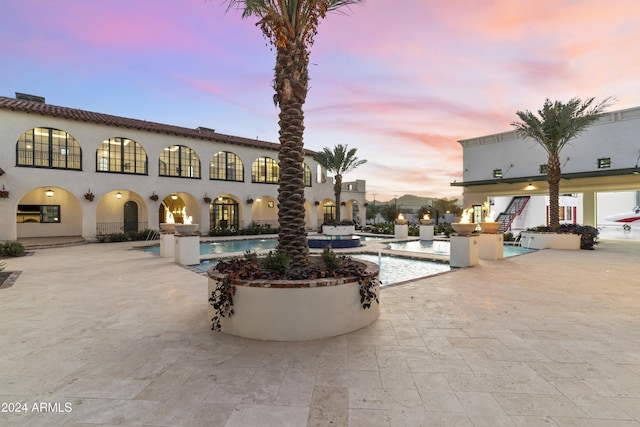 pool at dusk featuring a patio area