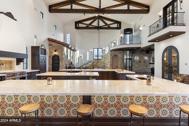 kitchen featuring tasteful backsplash, custom exhaust hood, double oven range, sink, and high vaulted ceiling