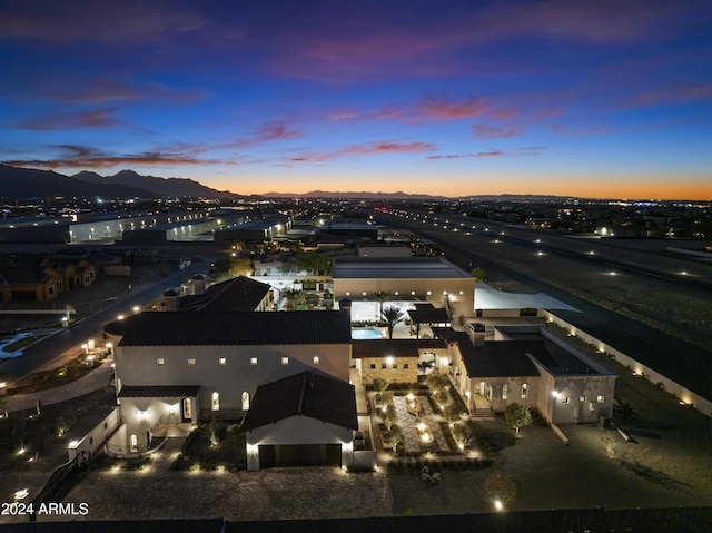 aerial view at dusk featuring a mountain view