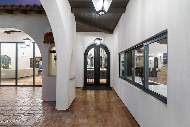 entrance foyer with beam ceiling, french doors, wood ceiling, and plenty of natural light