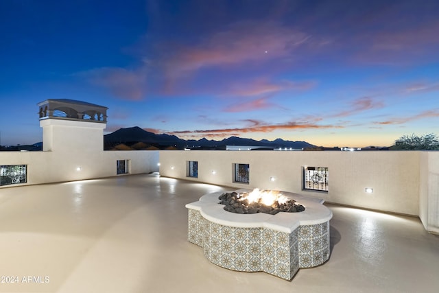 patio terrace at dusk featuring an outdoor fire pit