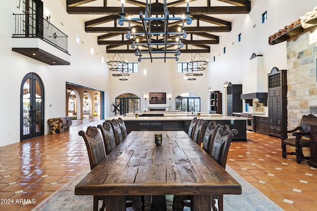 dining space with beam ceiling, a towering ceiling, french doors, and a notable chandelier