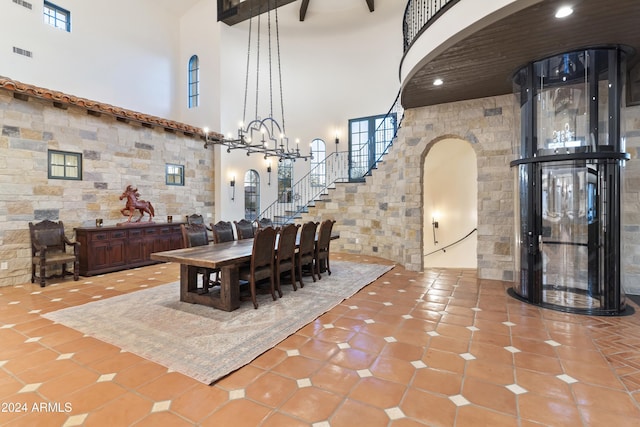 dining room with a high ceiling, an inviting chandelier, and tile patterned flooring