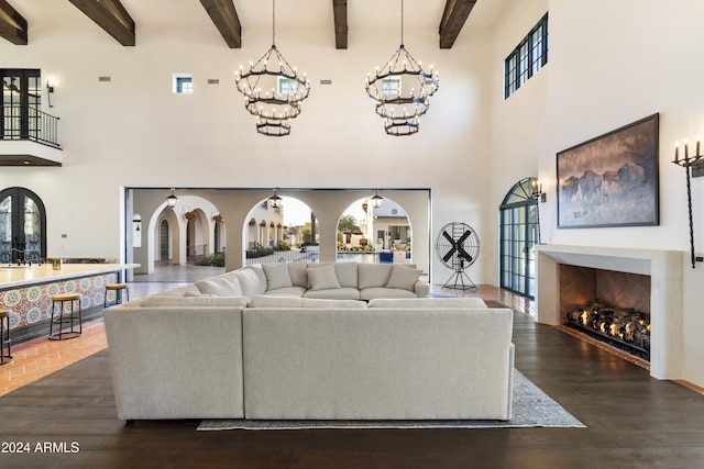 living room featuring beamed ceiling, dark hardwood / wood-style flooring, and a towering ceiling