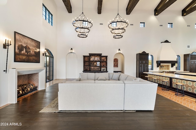 living room with a towering ceiling, dark hardwood / wood-style floors, and beamed ceiling