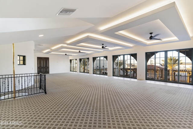 interior space with ceiling fan and a tray ceiling