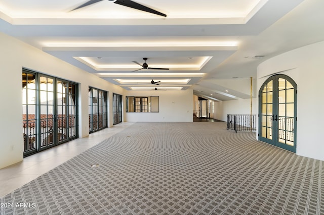 interior space featuring light tile patterned floors, a tray ceiling, and french doors