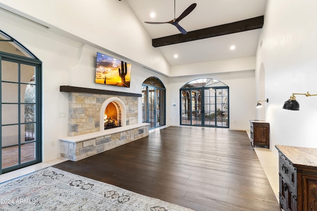 living room featuring light hardwood / wood-style floors, ceiling fan, a fireplace, french doors, and high vaulted ceiling