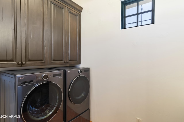 clothes washing area with washer and dryer and cabinets