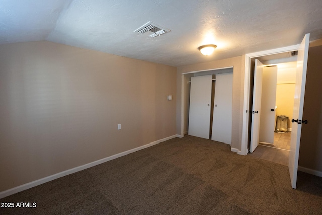 349 E Central Ave, Coolidge, AZ 85128 - unfurnished bedroom featuring lofted ceiling, a closet, baseboards, visible vents, and carpet floors