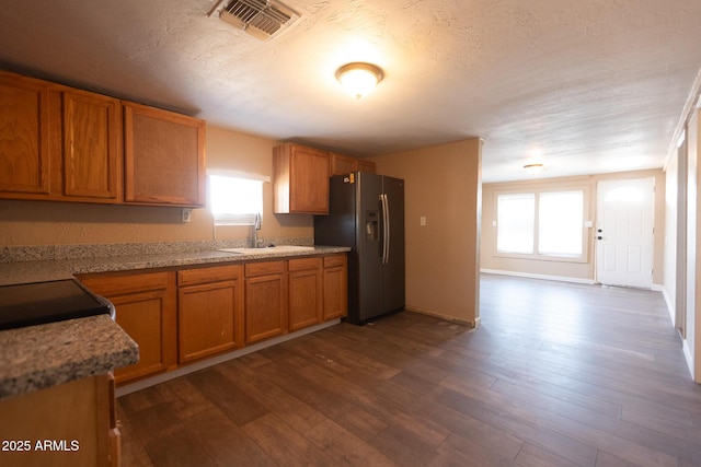 349 E Central Ave, Coolidge, AZ 85128 - kitchen featuring a sink, brown cabinetry, stainless steel fridge with ice dispenser, and plenty of natural light