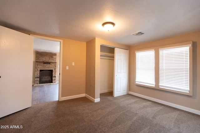 349 E Central Ave, Coolidge, AZ 85128 - unfurnished bedroom featuring carpet flooring, a closet, visible vents, baseboards, and a stone fireplace