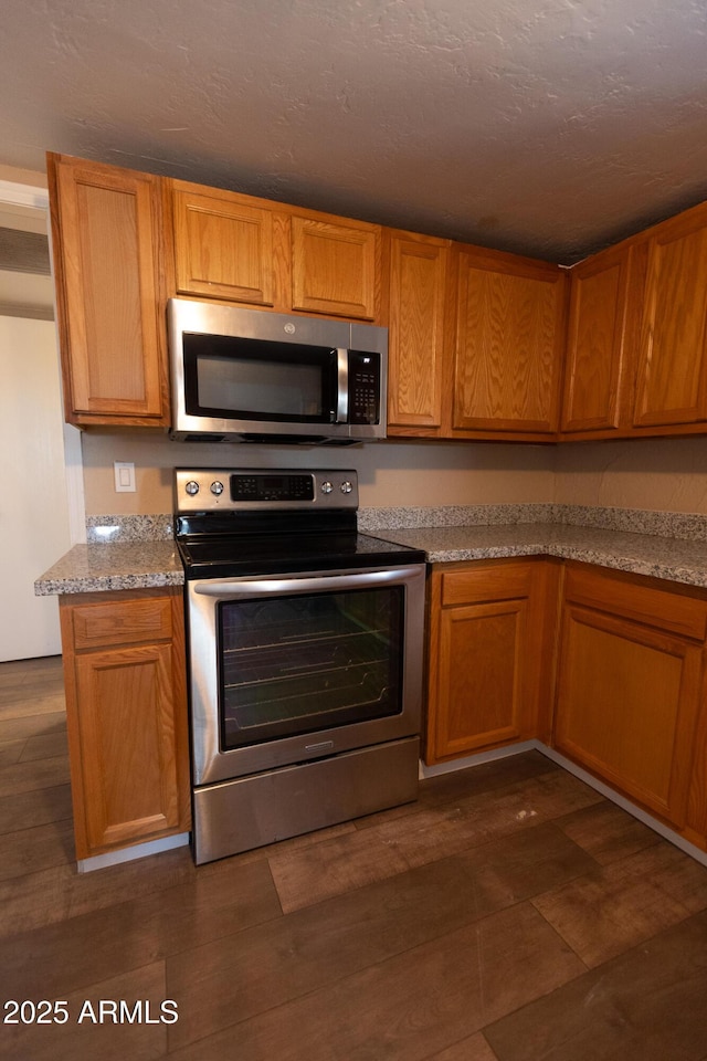 349 E Central Ave, Coolidge, AZ 85128 - kitchen featuring stainless steel appliances, brown cabinetry, and dark wood-style floors