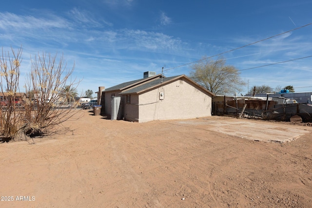 349 E Central Ave, Coolidge, AZ 85128 - view of side of home with central AC unit, fence, and stucco siding