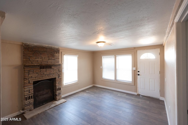 349 E Central Ave, Coolidge, AZ 85128 - unfurnished living room featuring baseboards, a fireplace, a textured ceiling, and wood finished floors