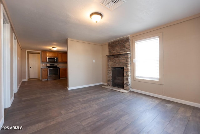 349 E Central Ave, Coolidge, AZ 85128 - unfurnished living room with visible vents, a fireplace, baseboards, and dark wood-type flooring