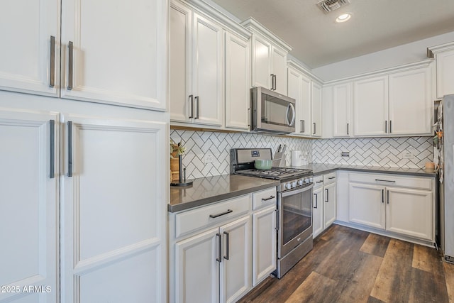 9752 E Torino Ave, Mesa, AZ 85212 - kitchen featuring appliances with stainless steel finishes, dark countertops, dark wood-style floors, white cabinetry, and recessed lighting