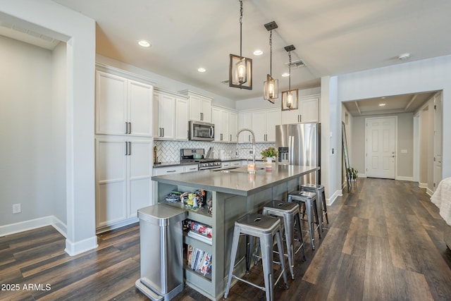 9752 E Torino Ave, Mesa, AZ 85212 - kitchen featuring appliances with stainless steel finishes, white cabinetry, a sink, a breakfast bar, and recessed lighting