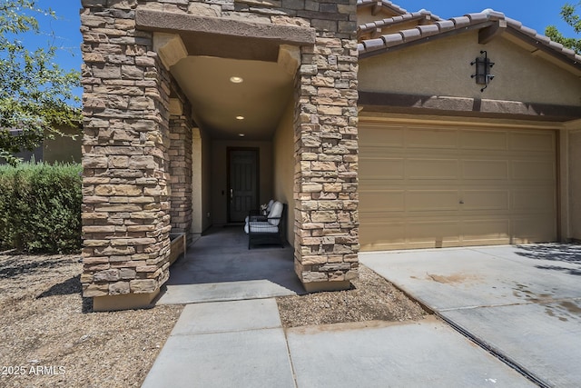 9752 E Torino Ave, Mesa, AZ 85212 - view of exterior entry featuring stone siding, concrete driveway, stucco siding, and an attached garage
