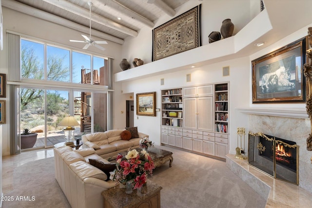 7728 E Mary Sharon Dr, Scottsdale, AZ 85266 - living room featuring a towering ceiling, wooden ceiling with exposed beams, a high end fireplace, a ceiling fan, and built in features