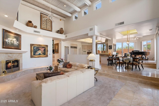 7728 E Mary Sharon Dr, Scottsdale, AZ 85266 - living area with a towering ceiling, a ceiling fan, a high end fireplace, and wooden ceiling with exposed beams