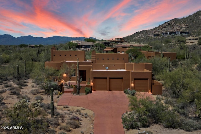 7728 E Mary Sharon Dr, Scottsdale, AZ 85266 - pueblo-style house featuring a mountain view, driveway, stucco siding, a chimney, and a garage
