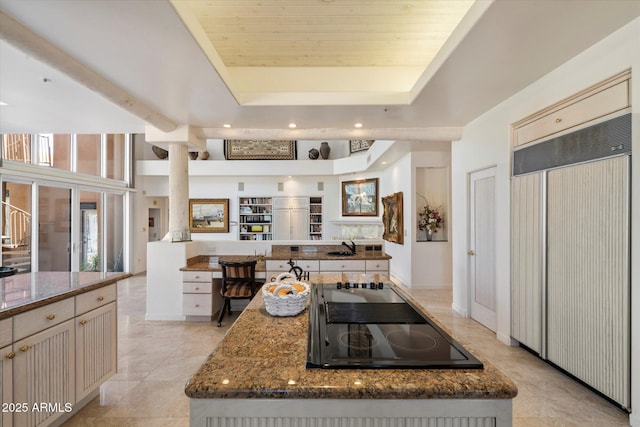 7728 E Mary Sharon Dr, Scottsdale, AZ 85266 - kitchen featuring paneled built in fridge, black electric stovetop, a raised ceiling, dark stone counters, and recessed lighting