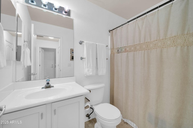 full bath featuring a shower with shower curtain, toilet, and vanity