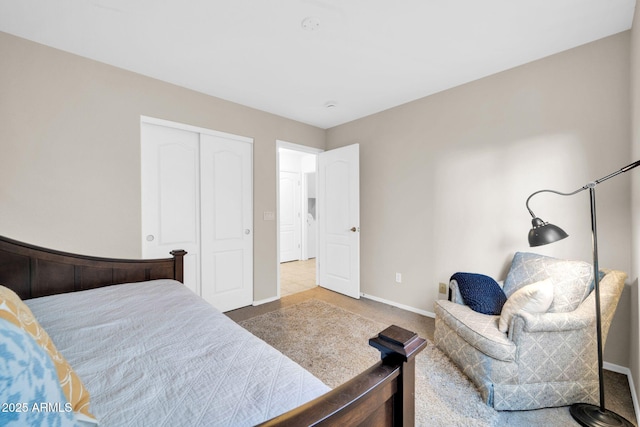 carpeted bedroom featuring a closet and baseboards